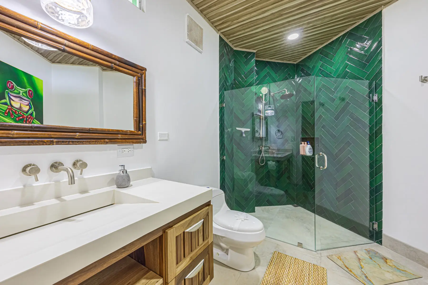 A walk-in shower tiled in deep green glass