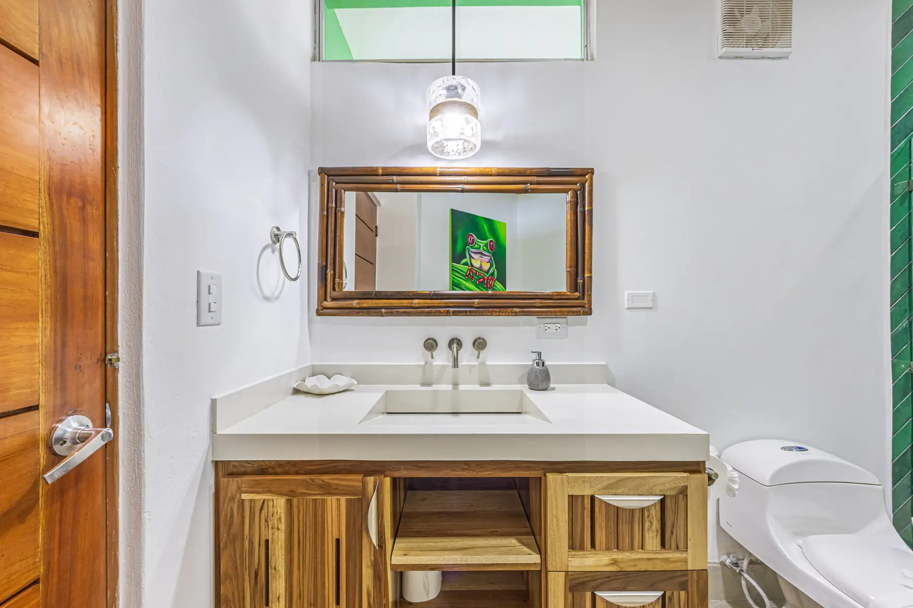 A bathroom vanity with a framed mirror and hardwood cabinetry