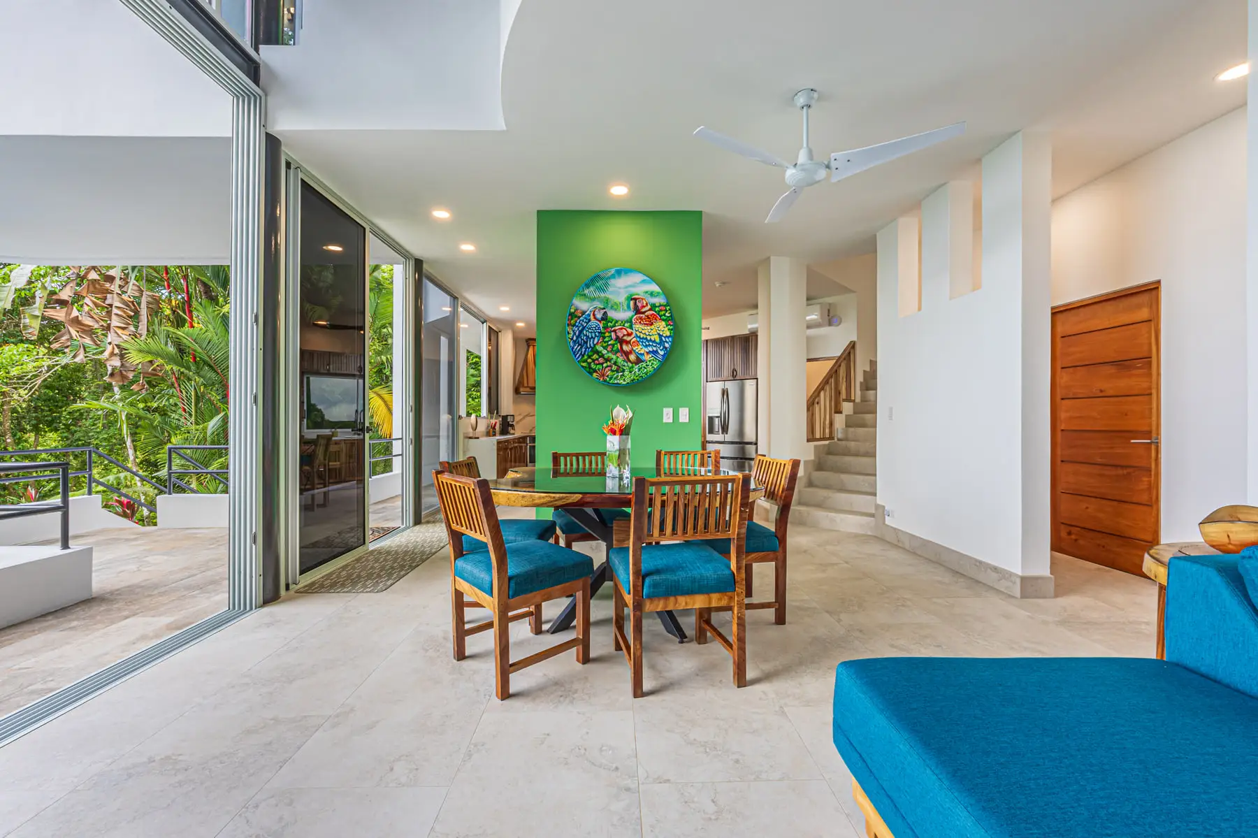 The indoor dining table set for six beside the glass wall
