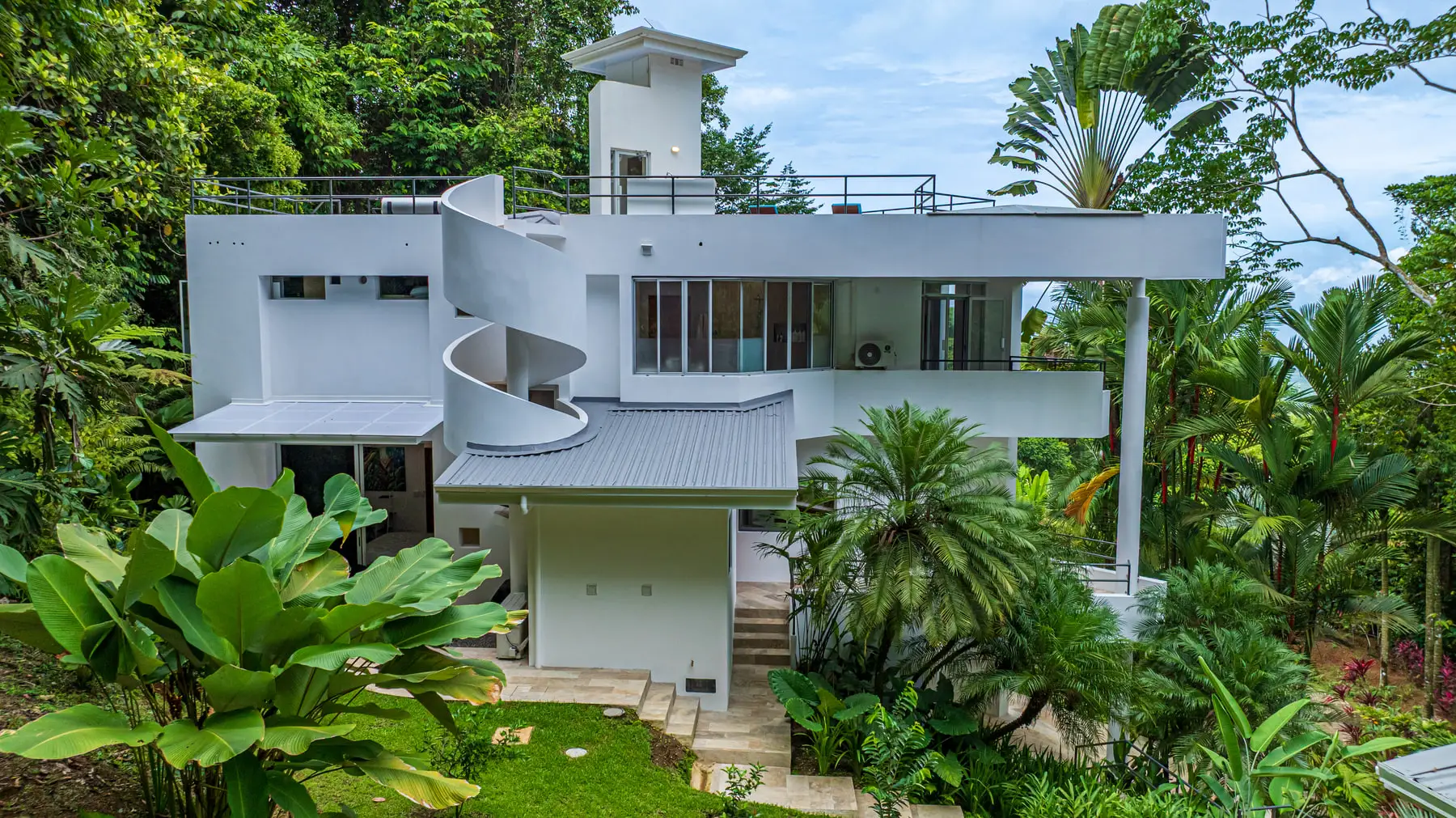 The front of the house from the air, showing the curved stair tower and the roof deck