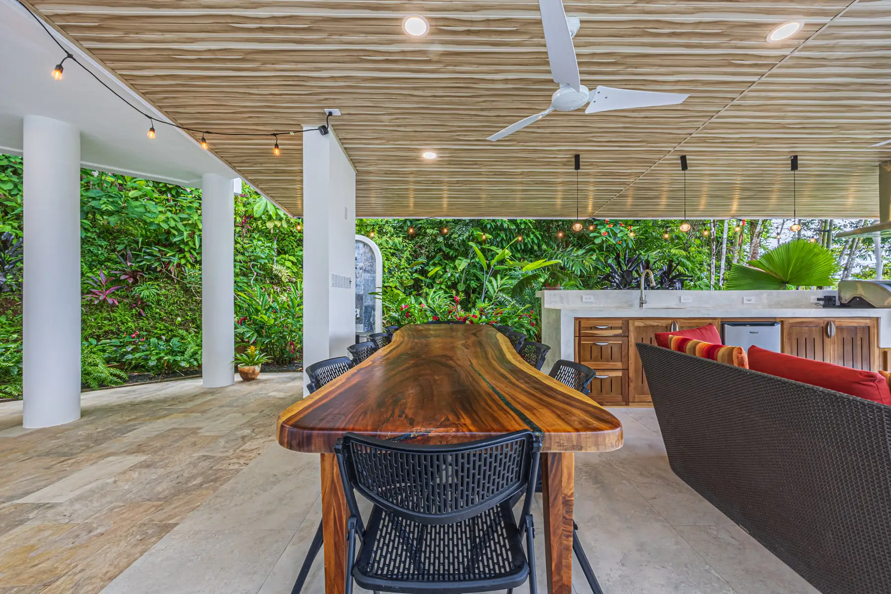 The live-edge hardwood bar under the covered terrace, looking out to the forest