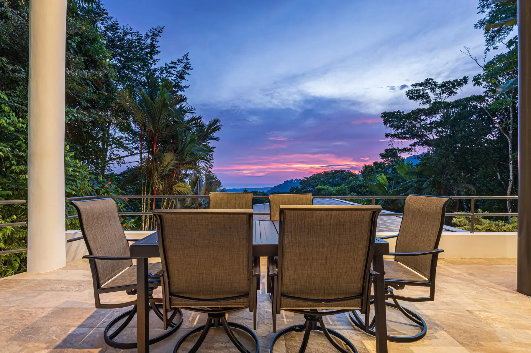 The outdoor dining table at dusk, with a pink sky over the ridgeline