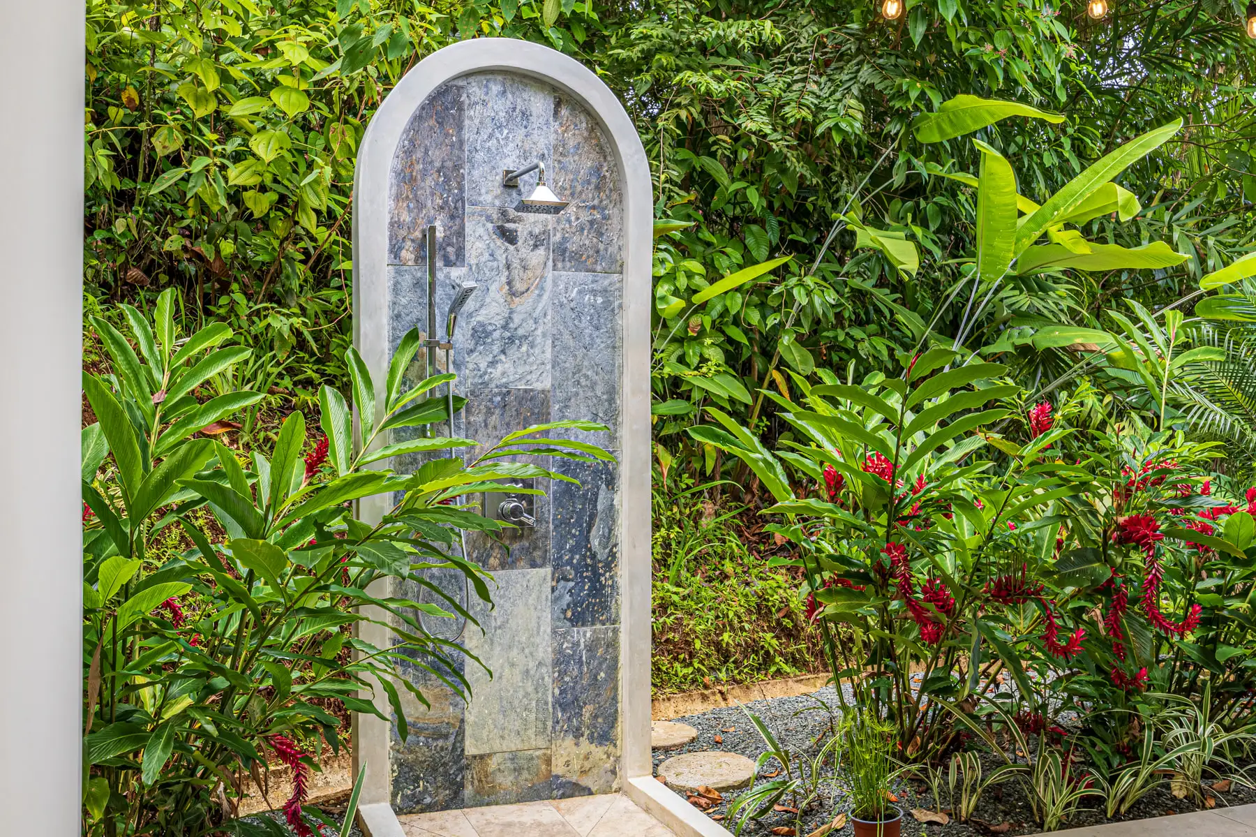 The stone outdoor shower, set into planting and open to the jungle