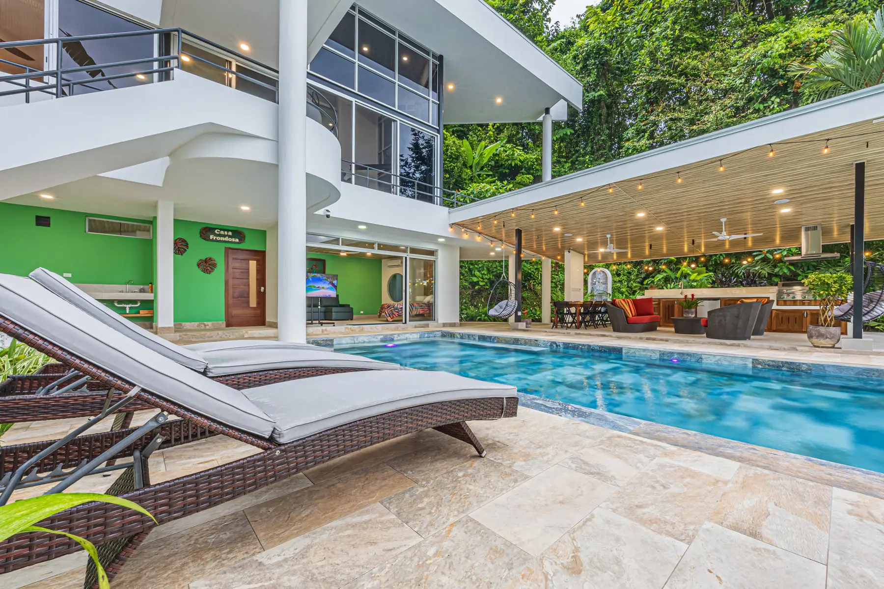 Sun loungers along the pool terrace in the afternoon, with the house behind