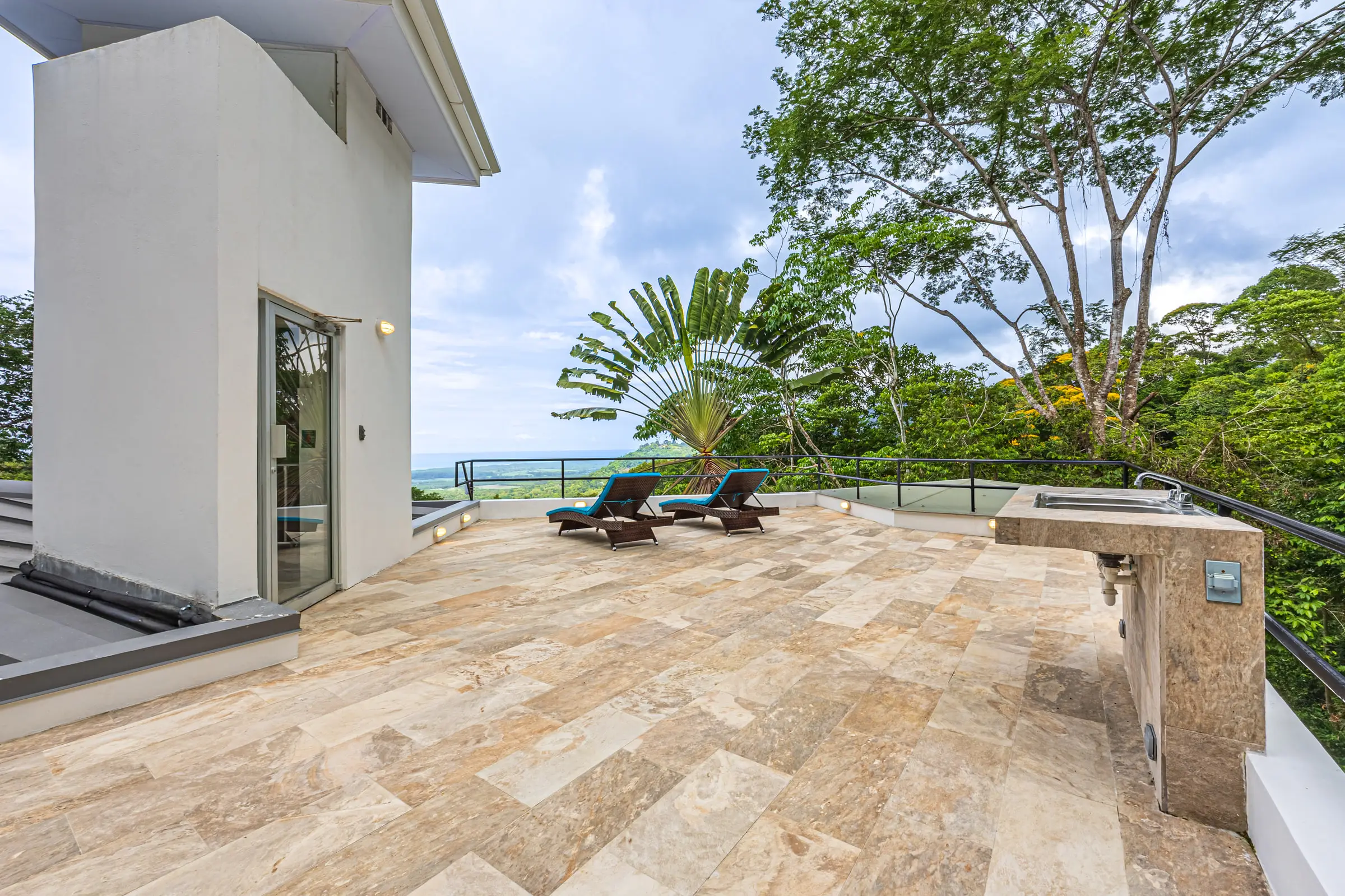 The stone terrace looking out over the treetops to the Pacific