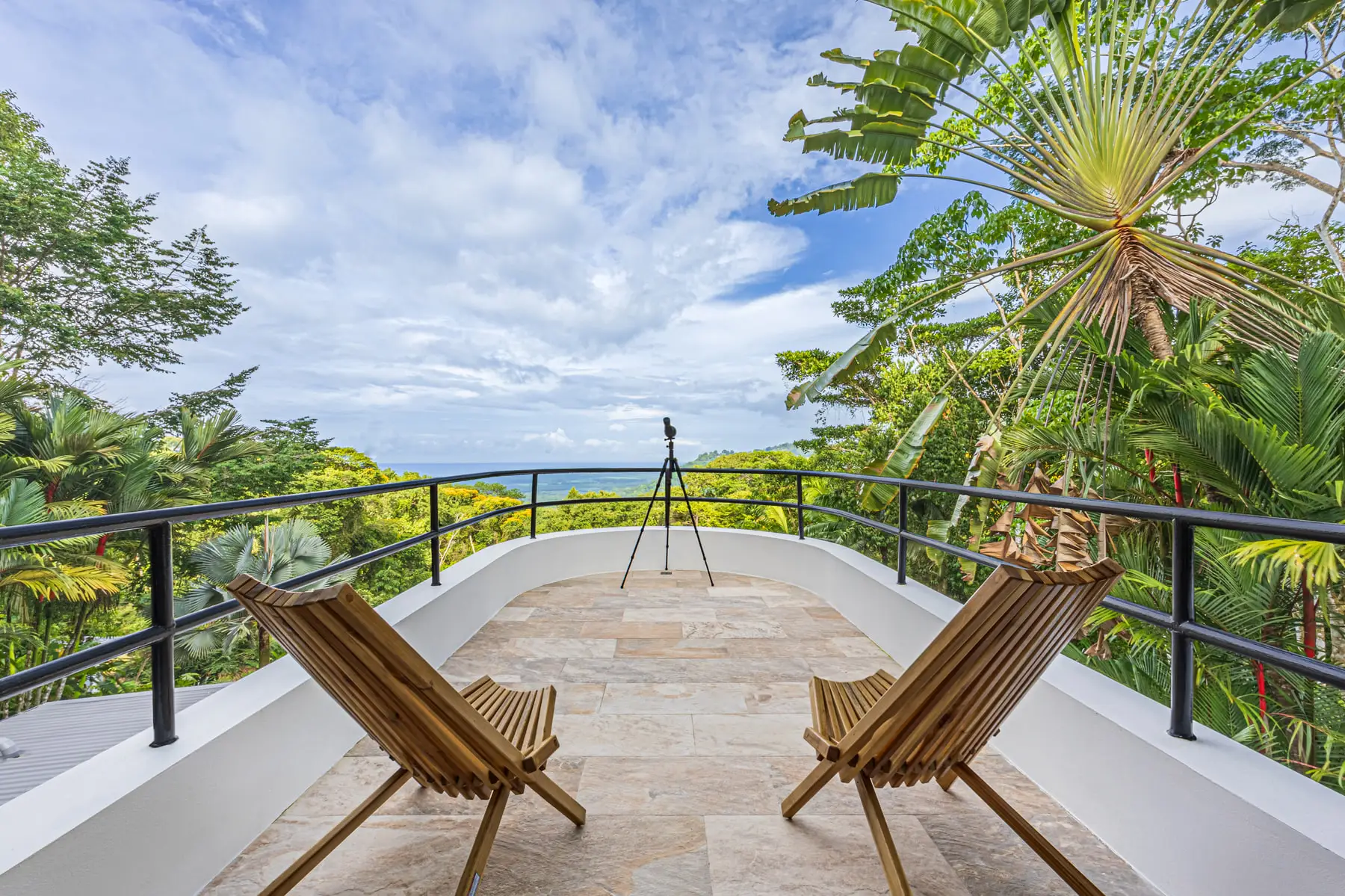 The third-floor deck by day, with chairs facing the ridgeline and the sea beyond